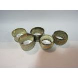 Four silver napkin rings and another