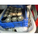 A basket of assorted china tea wares and a box of tea lighters