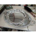 An oval plated twin handled tray and a wavy rim plated tray on cabriole feet