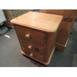 A pine bedside three drawer chest,