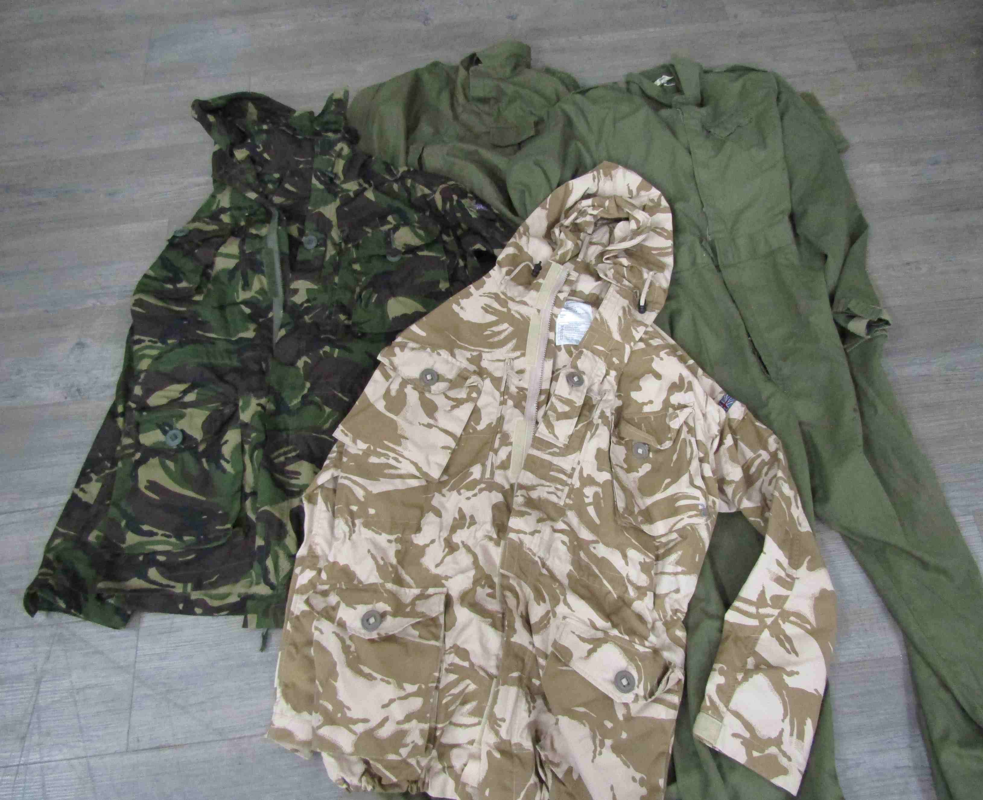 A box of miscellaneous post-war uniform including overalls together with two camo backpacks