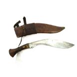 A kukri knife, the brass bound hardwood grip joining a curved blade bearing date 1917