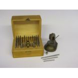 A small cast brass staking tool and a cased set of steel punches,