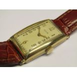 ELGIN: A 1930's gold plated and steel cased gent's manual wind wristwatch of curvex form,