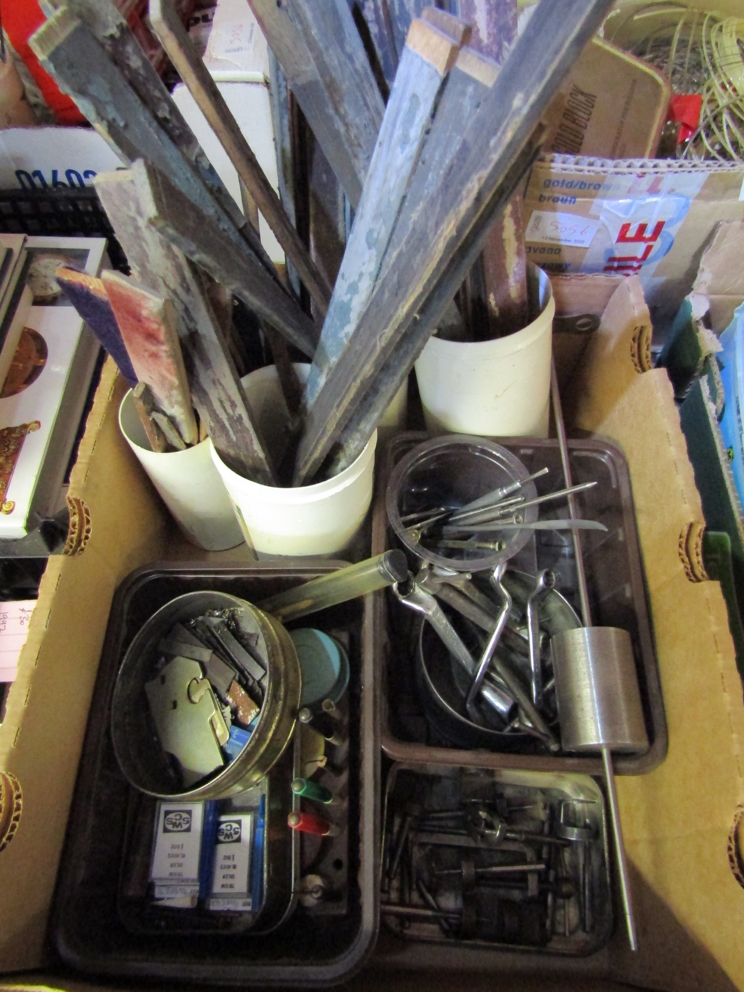 Three boxes of mixed horological raw materials/consumables including oilers, emery laps, shellac,