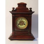 A late 19th Century mahogany mantel clock of architectural form, enamelled Roman chapter ring,