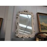 An ornate painted resin framed wall mirror