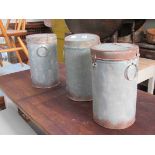 Three tin storage cylinders