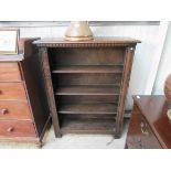 An oak bookcase with carved top and sides,