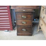An oak pedestal chest of three drawers with pull-out slide,