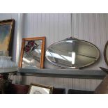 An Art Deco copper framed oval wall mirror and a pine framed mirror with coloured lead roses