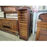 An Edwardian oak tambour roll front filling unit with twelve interior trays, no key,