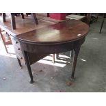 A Georgian mahogany demi-lune fold top tea table with fold-over top,