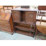 An Art Nouveau oak cupboard bookcase with two carved doors