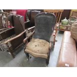 An early 19th Century mahogany framed scroll arm arm-chair on turned legs to castors,