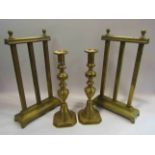 A pair of turned brass candle sticks and a pair of brass fire tool stands