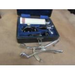 A cased medical instrument by Keeler and a stainless steel clamp instrument (2)