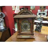 An early 20th Century walnut bracket clock of architectural form with bras dial and silvered Arabic