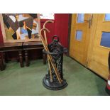 A Victorian style cast iron stick stand and three walking sticks
