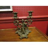 A brass twin sconce candlestick with lady playing musical instrument,
