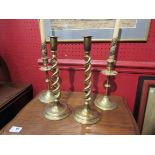 A pair of brass helix form candlesticks and another pair