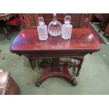 A mahogany card table with gadrooned beading over a spreading square column on quatreform base with