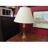 A brass table lamp with cream shade,