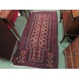 A red and brown Eastern rug with multiple geometric borders,