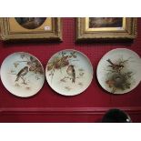 A set of three hand painted chargers decorated with birds,