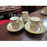 A set of six Cauldon china white and green ground cups and saucers, the cups with silver mounts,