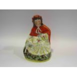 A Staffordshire figure of little red riding hood, chipped wolf's ear,