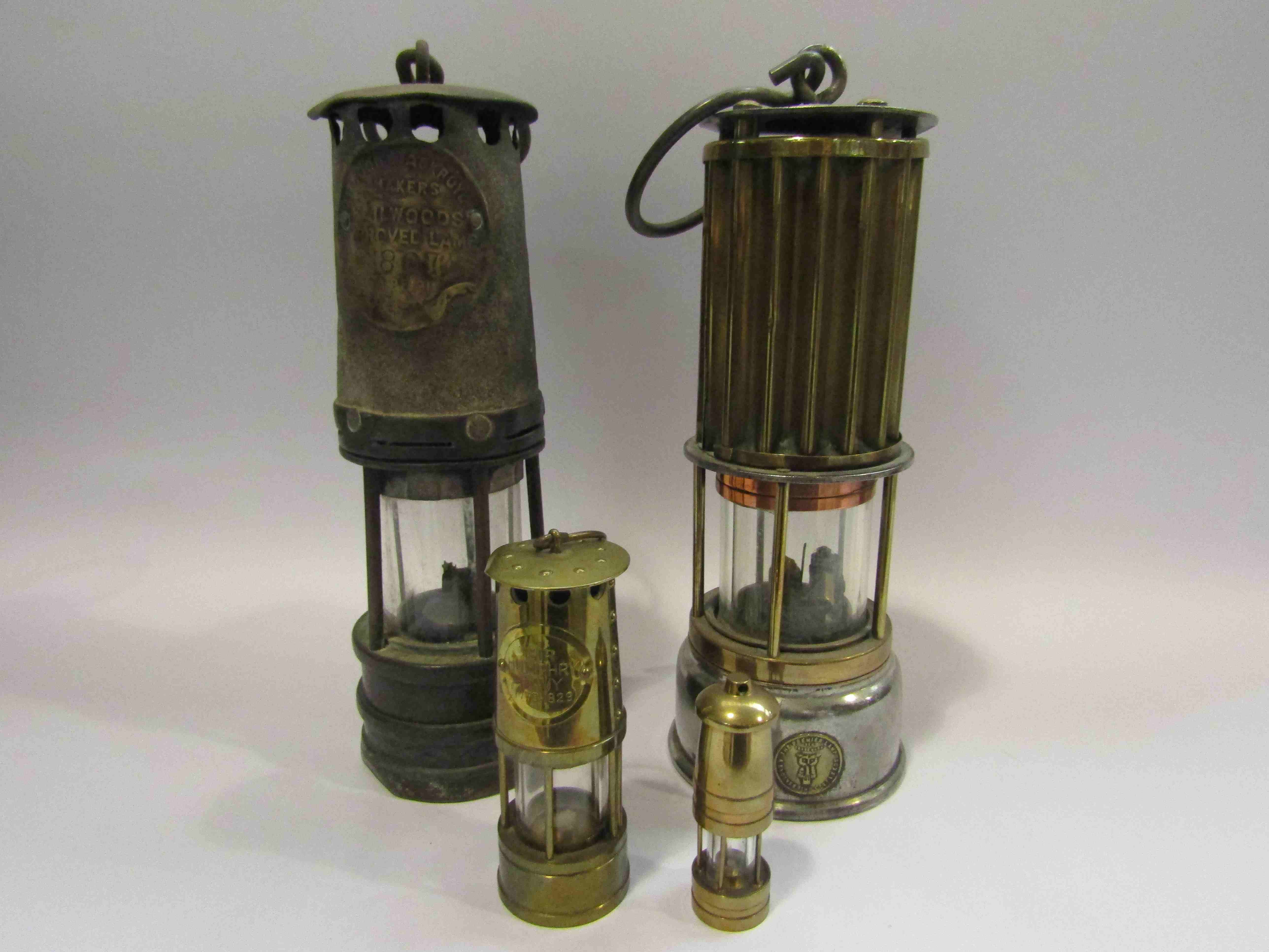 Four assorted miners lamps including miniature examples