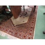 An Eastern beige ground wool rug with central star and multiple geometric borders,