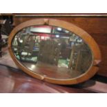An oval wall mirror in oak frame,