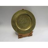 A 20th Century Oriental brass charger decorated with dragons with stand,