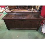 An 18th Century oak four panel hall coffer the hinged lid over turned stile feet,
