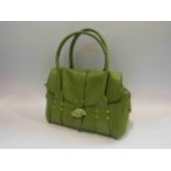 A Radley green leather lady's handbag with central zippered compartment flanked by two open