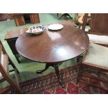 A George III mahogany revolving circular tilt top wine table on a cannon barrel column and tripod