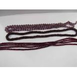 A garnet bead necklace and two other facet cut bead necklaces