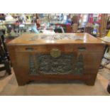 A Japanese camphor wood chest with lid carved with pagoda and figural scenes,