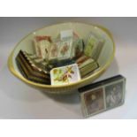 A mixing bowl containing vintage packs of playing cards, travelling chess etc.