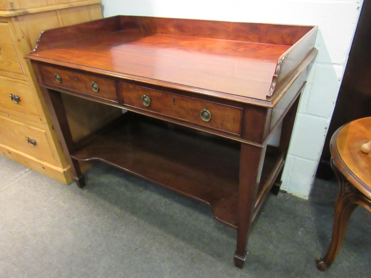 Circa 1860 a mahogany two tier washstand the three quarter raised back and one piece top over two