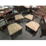 A set of four Edwardian carved dining chairs on turned legs