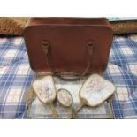 A leather handbag with vintage brush/mirror set