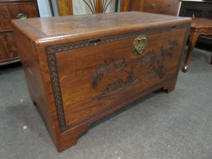 A mid 20th Century Southeast Asia camphor wood trunk with carved decoration and sliding tray (with