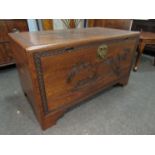 A mid 20th Century Southeast Asia camphor wood trunk with carved decoration and sliding tray (with