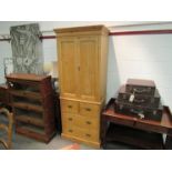 A natural pine two door wardrobe with key over two short and two long drawers,