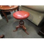 A Victorian swivel top music stool with carved tripod base