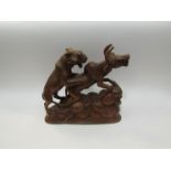 A carved wood figure of lion attacking bison,