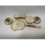 A yellow metal dressing table set comprising of mirror, brush, a pair of candlesticks,
